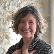 Ali, a life coach for mothers, is smiling.