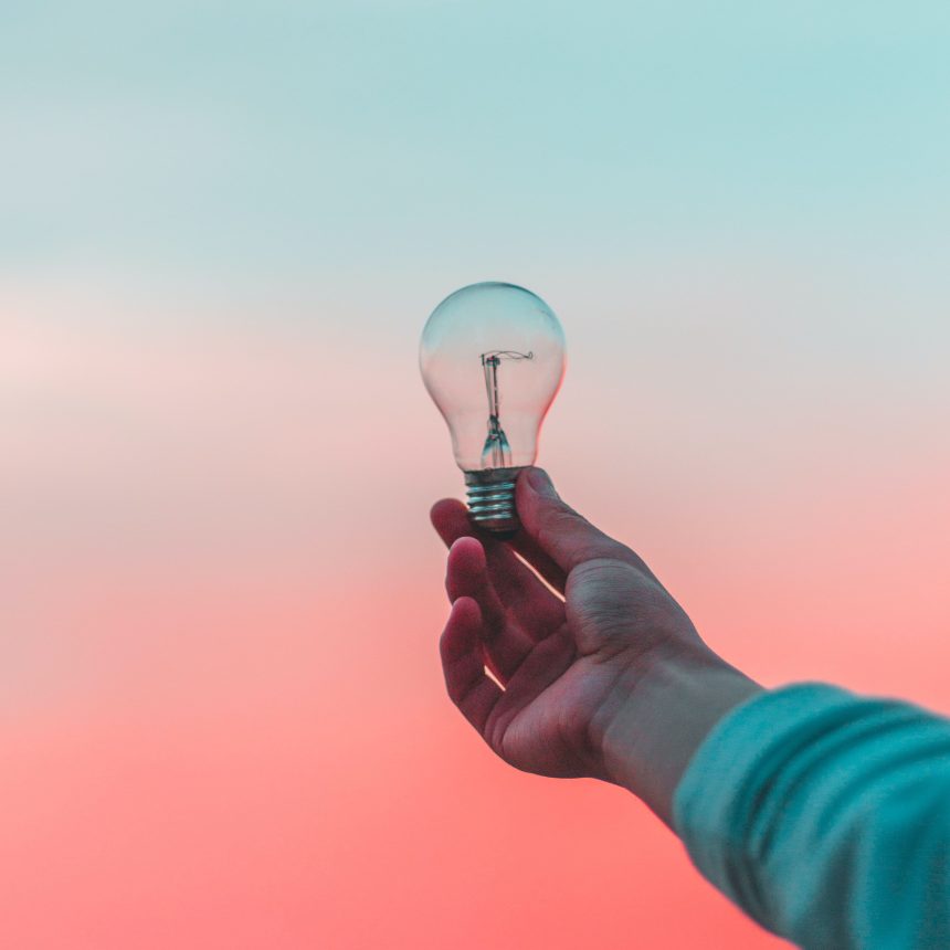 A hand holds ClarityQuest: A 3-Month Life Elevator, symbolized by a clear light bulb, against a soft pastel sky with blue and pink gradients.