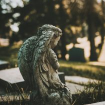 Small statue of an angel with its face looking away from the camera. This imagery represents how to navigate grief.
