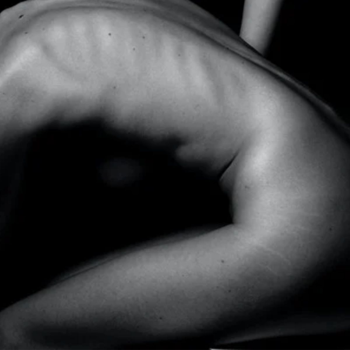 A black and white photo of a person's side, showing defined ribs and muscles in dramatic lighting—perfect for showcasing the results of The Shifter Training Session’s injury prevention benefits.