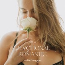 A woman with long blonde hair in black lace lingerie holds a white rose, eyes closed and smiling softly. The text reads: Endless Romance. I AM A DEVOTIONAL ROMANTIC. Discover our couples coaching program—aidaforjoy.