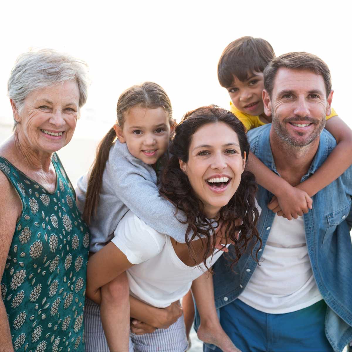 A smiling family of five poses outdoors, radiating happiness gained from Family and Relationship Consultation, which helps strengthen bonds and create positive memories for all ages.
