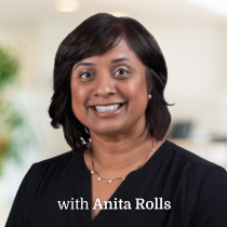 A woman with dark hair smiles at the camera in a professional setting. She is wearing a black top and necklace. Text at the bottom reads, with Anita Rolls.
