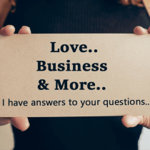 A person holding a sign that reads: Love.. Business & More.. I have answers to your questions.. The background is blurred, focusing on the sign and the persons hands.