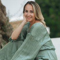 Scarlett Grace sitting outdoors in a light green dress