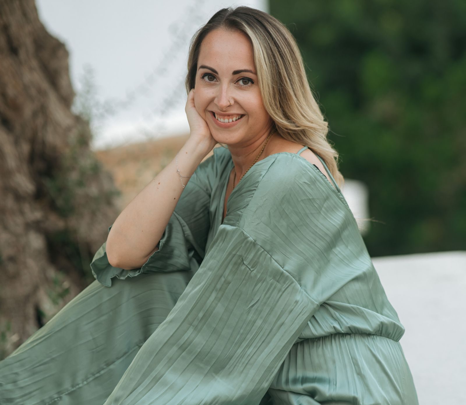 Scarlett Grace sitting outdoors in a light green dress
