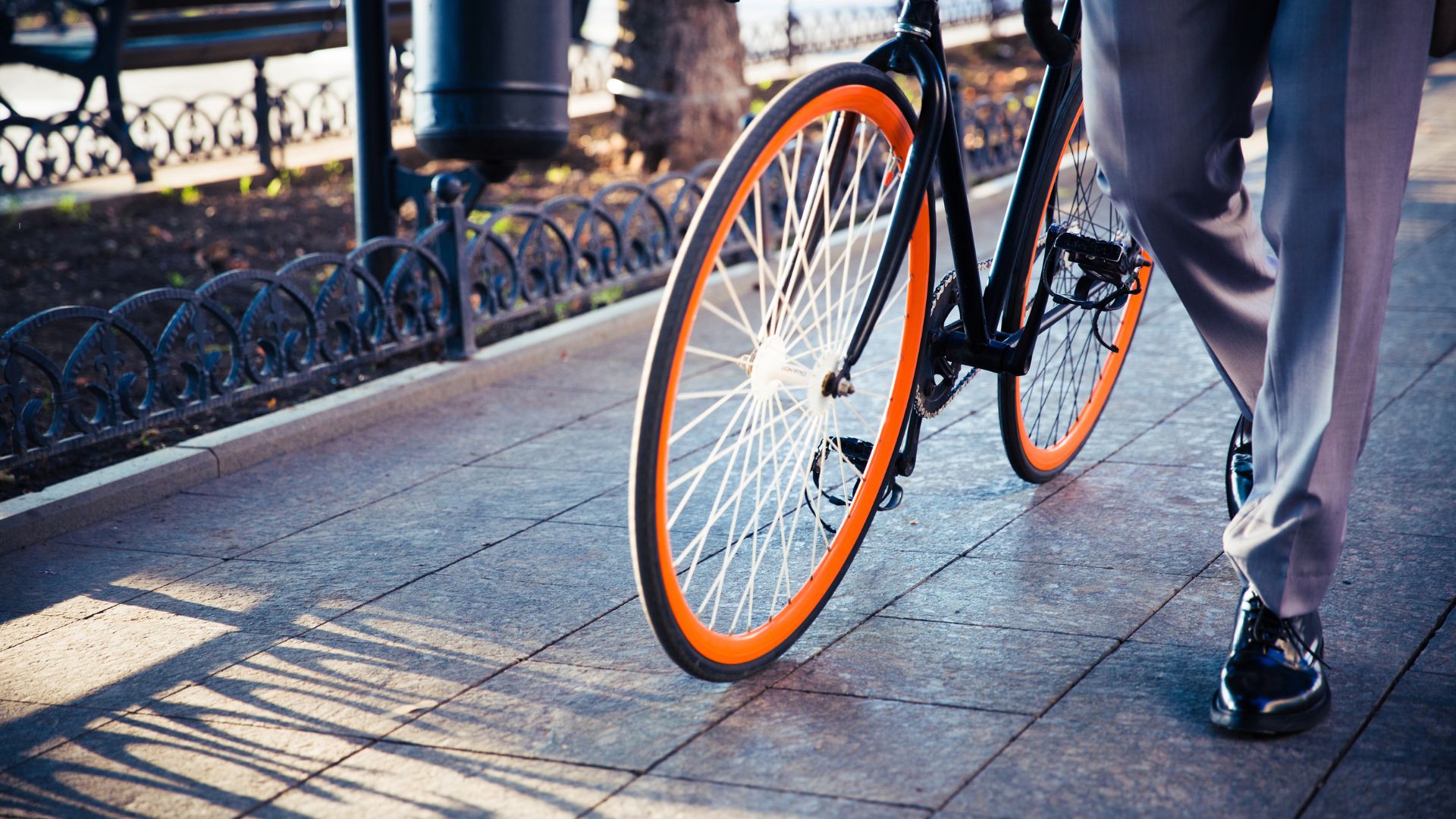 Professional walking with a bicycle after work to support movement and prevent burnout.