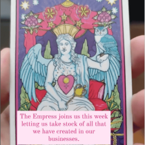 A hand holds The Empress tarot card—crowned, winged, blue-haired, with a scepter. Text overlay: “The Empress joins us this week… a reminder from spirit that you have come far.” Product: Tarot Reading.
