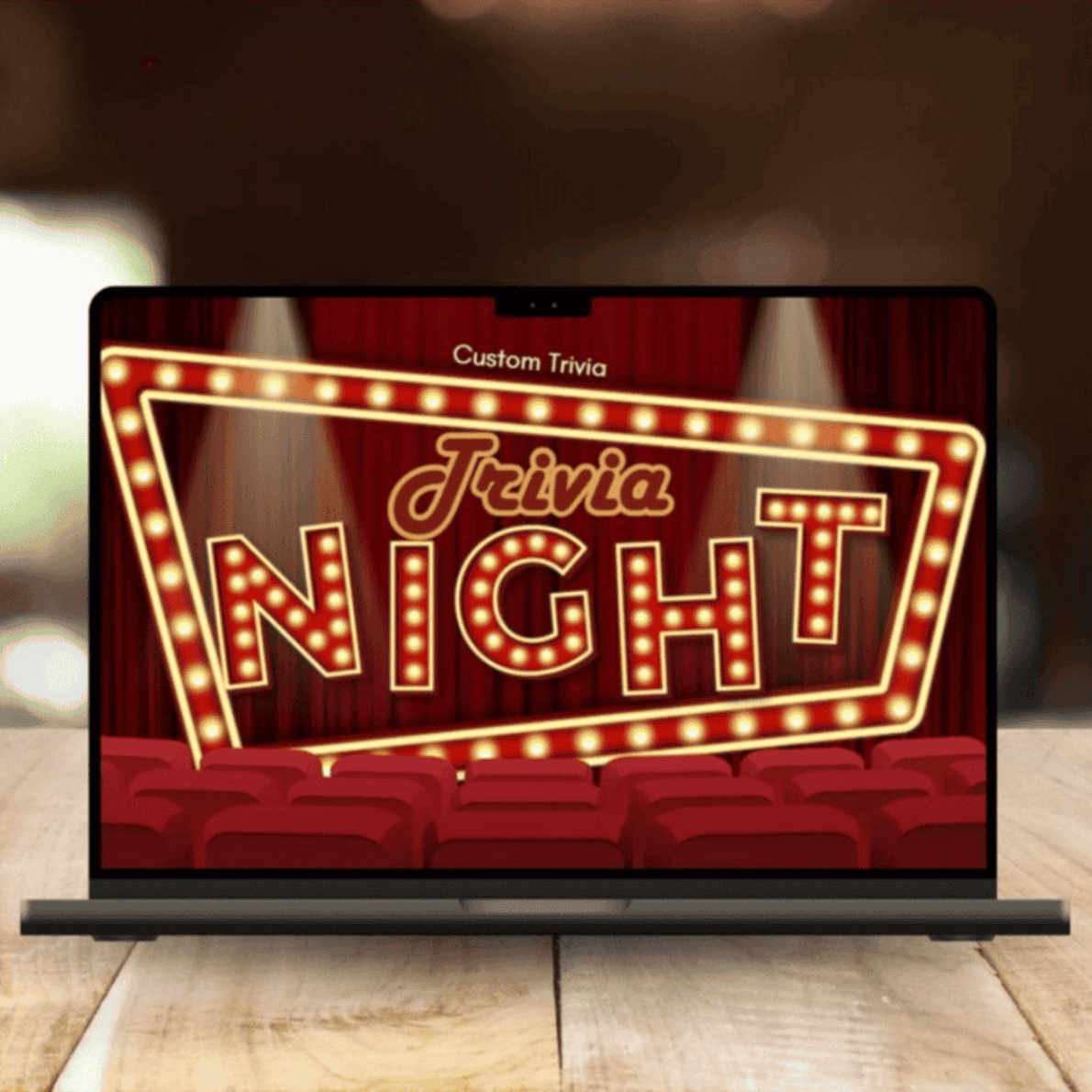 A laptop on a wooden table displays the Virtual Happiness Workshop for Team Building with a glowing "Trivia Night" marquee, surrounded by lights, red curtains, and theater seats—a fun and engaging virtual group activity.