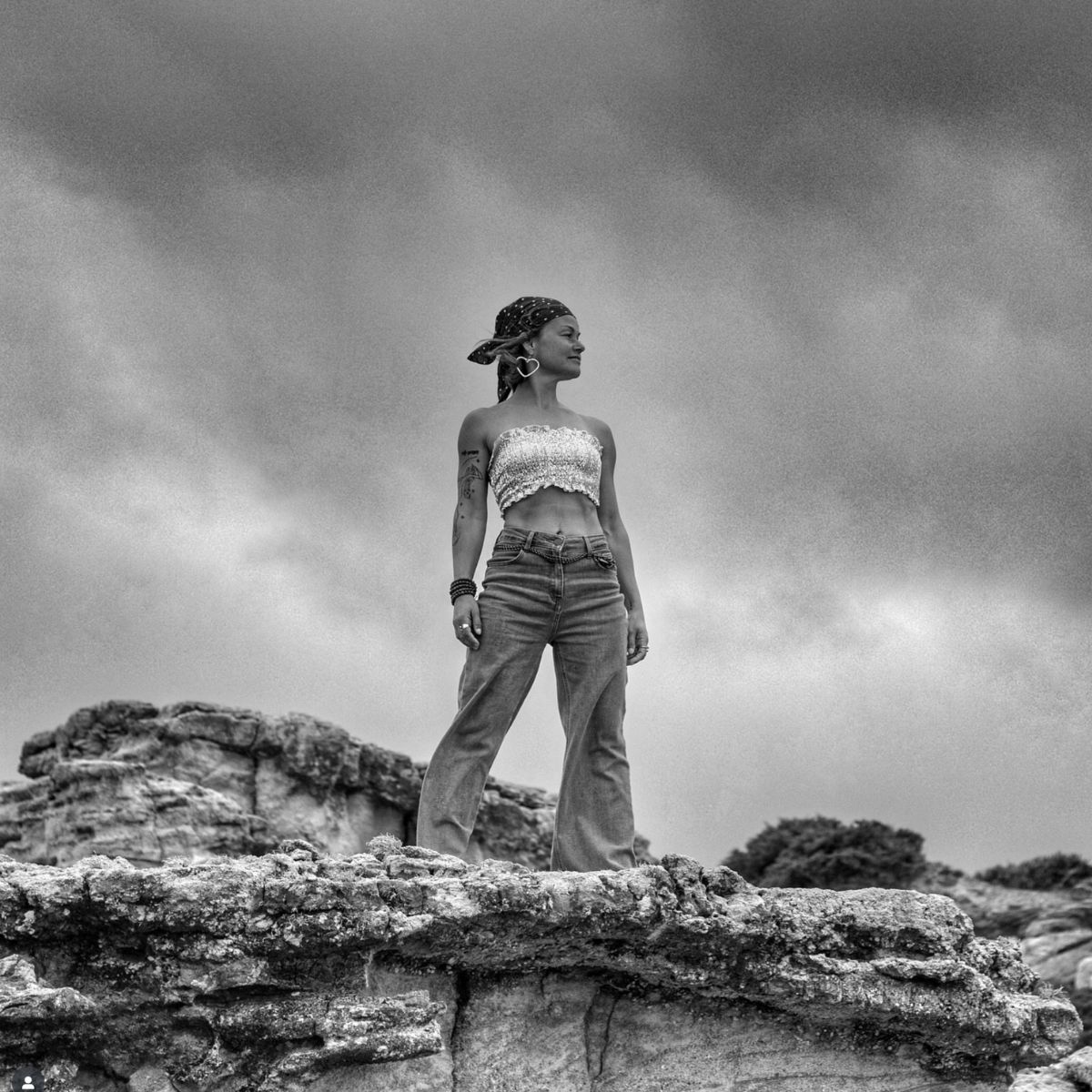 Sonia Ferreira standing on rocky ground beneath a cloudy sky
