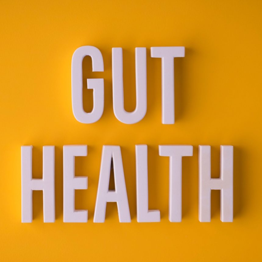 White 3D letters spelling GUT HEALTH on a bright yellow background.