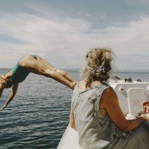 Woman diving from a boat into the Mediterranean during a Sicily yoga retreat