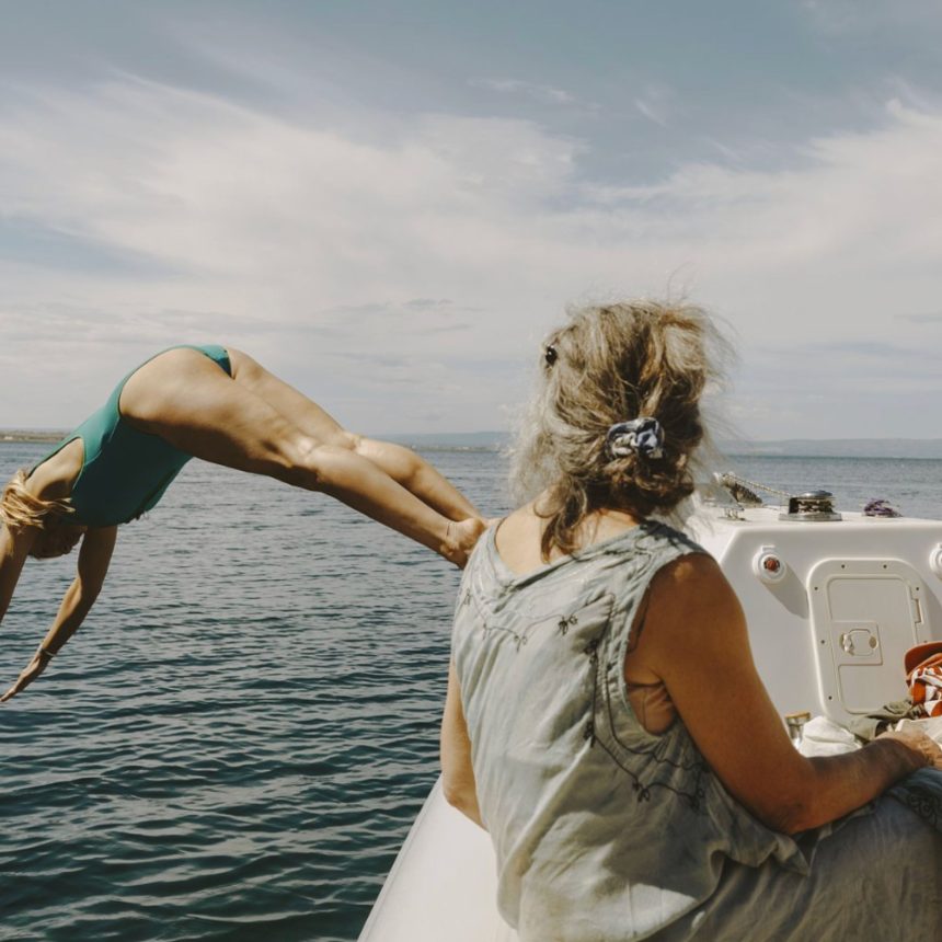 Woman diving from a boat into the Mediterranean during a Sicily yoga retreat