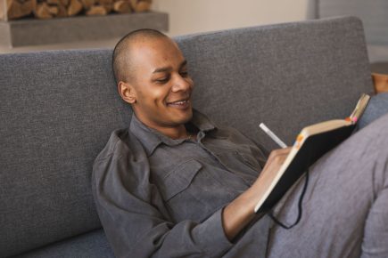 Man writing in a journal while practicing personal growth exercises